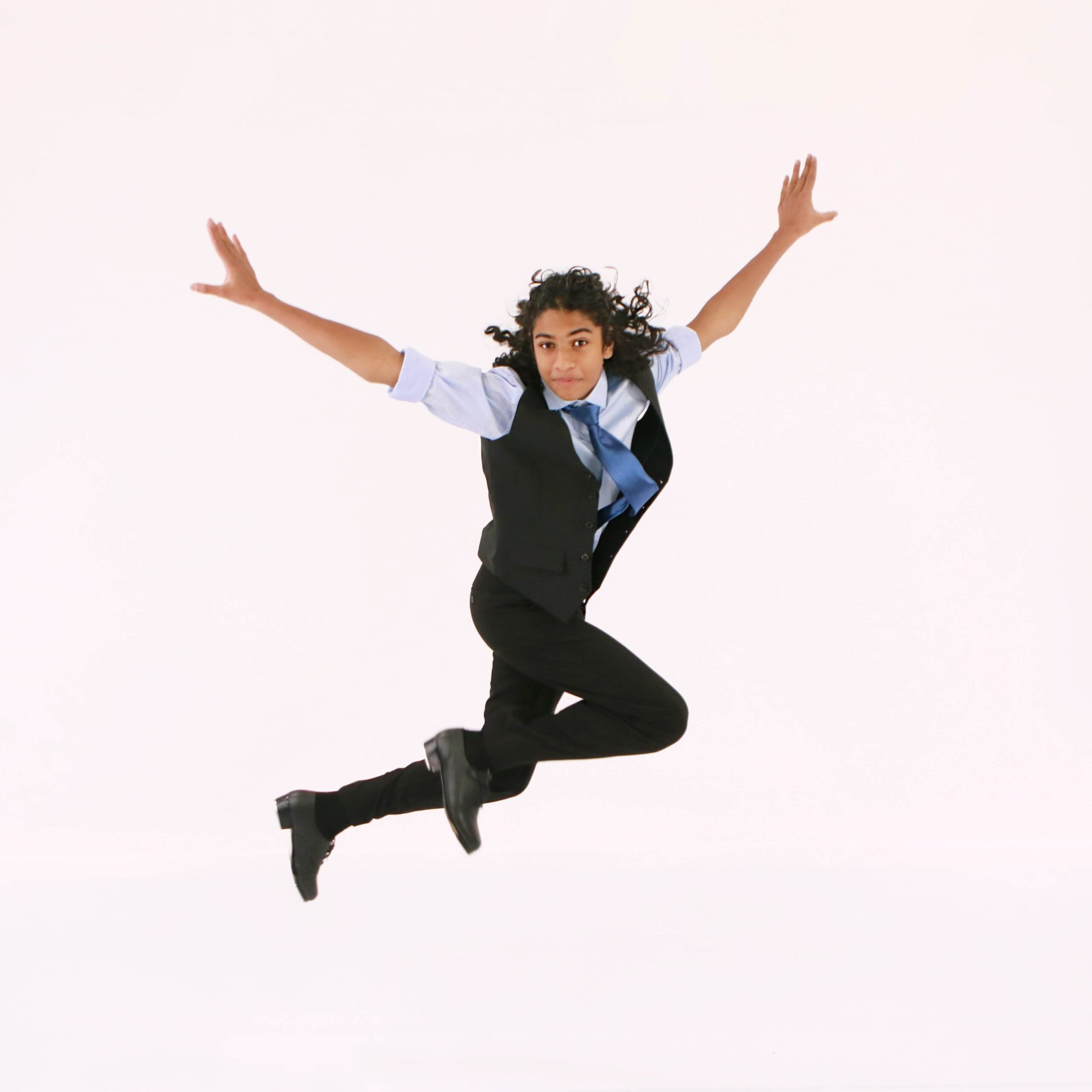 Male teenage tap dancer from The Dance Shoppe dance studio in Milton wearing a suit jumping in the air